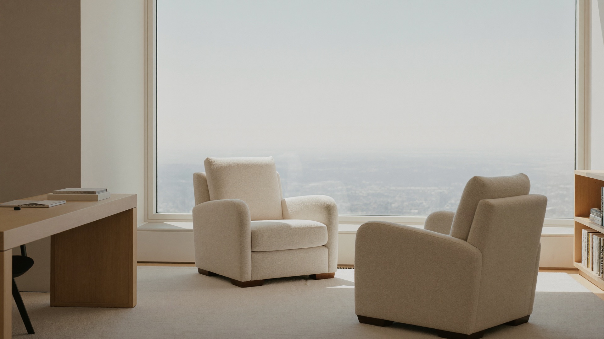 Heller Raum an der Spitze eines Hauses: zwei bequeme Sessel am großen Fenster mit weitem Blick über die Stadt.